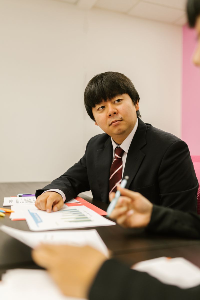회의실 책상에서 서류를 앞에 두고 앉아 있는 한국인 남성 실무자