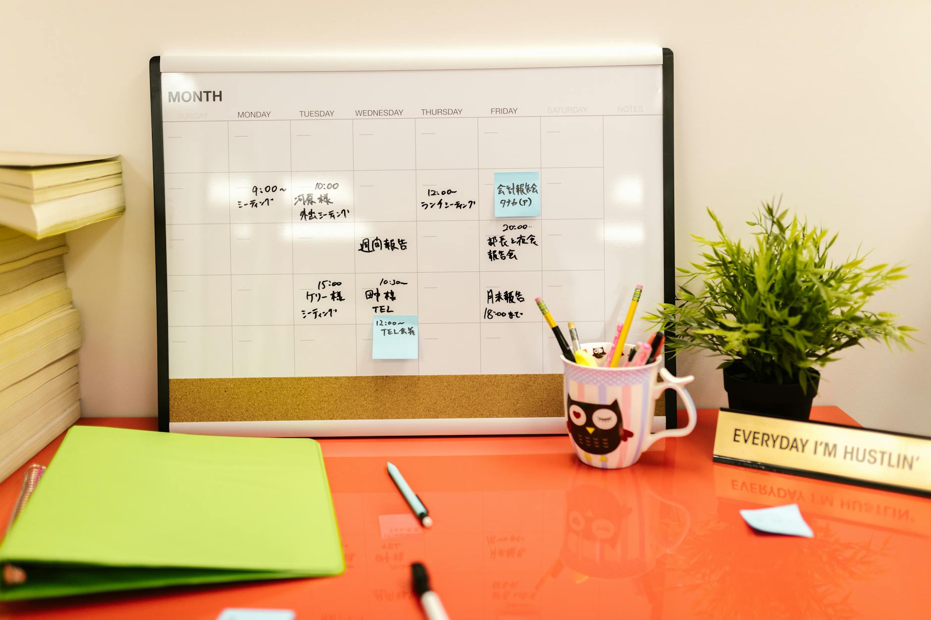 A Desk Calendar with Notes and Post Its on Orange Desk