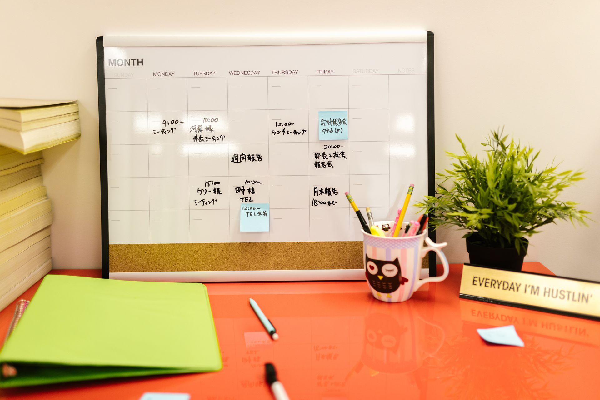 A Desk Calendar with Notes and Post Its on Orange Desk