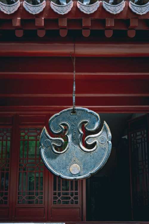 Free Exterior of traditional oriental temple decorated with bronze symbol of umpan hanging on entrance of building under pagoda roof Stock Photo