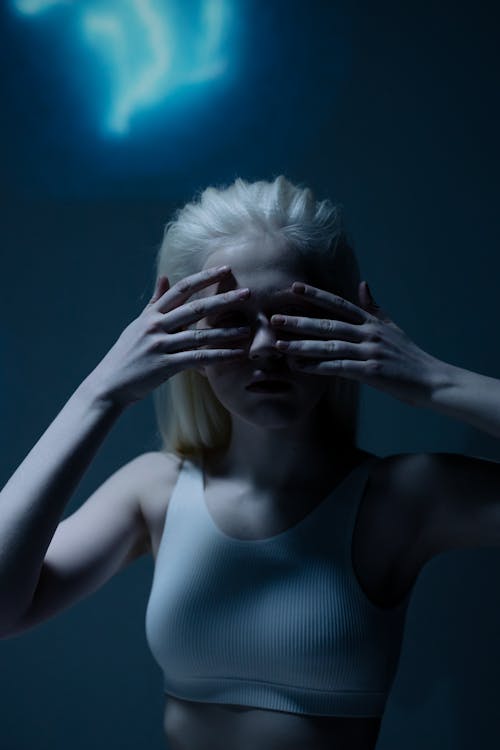 Woman in White Crop Top Covering Face