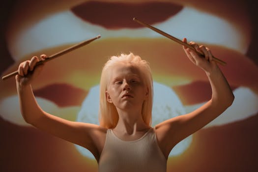 Artistic studio portrait of a woman with drumsticks against a dramatic background.