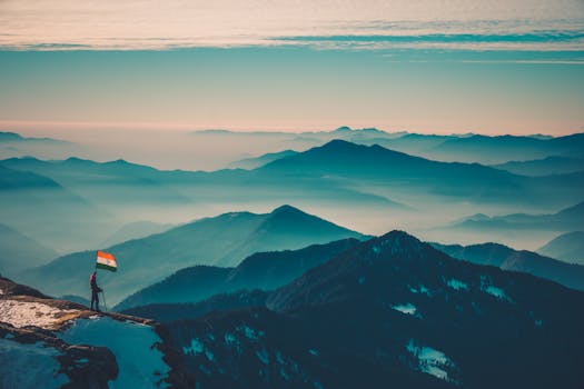 A breathtaking view of the majestic Himalayas with a person holding an Indian flag, showcasing natural beauty.