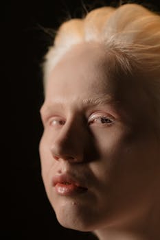 Close-up studio portrait capturing the unique beauty of a young albino woman in a soft light setting.