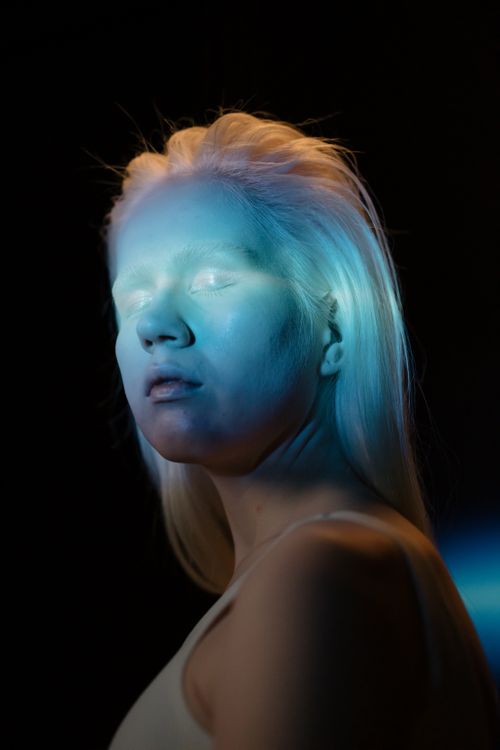 Free Artistic portrait of a woman in blue neon light, evoking a dreamy mood. Stock Photo