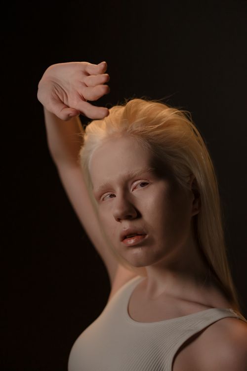 Free Stylish studio portrait of a blonde woman with backlighting, showcasing elegance and fashion. Stock Photo