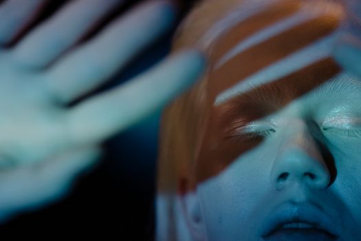 A creative close-up portrait of a woman with captivating shadow projections on her face.