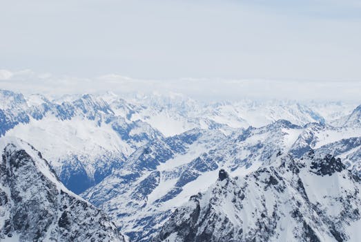 A stunning aerial view of a vast snow-covered mountain range during winter.
