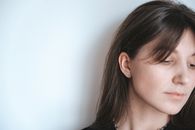 Woman Beside White Wall