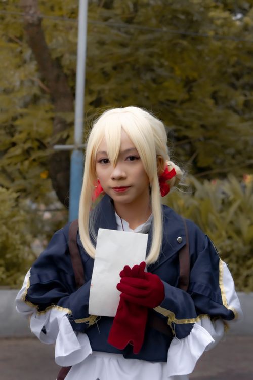 Free A woman in a detailed cosplay costume poses outdoors, holding a letter. Stock Photo