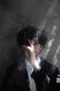 Calm man smoking cigarette in dark room