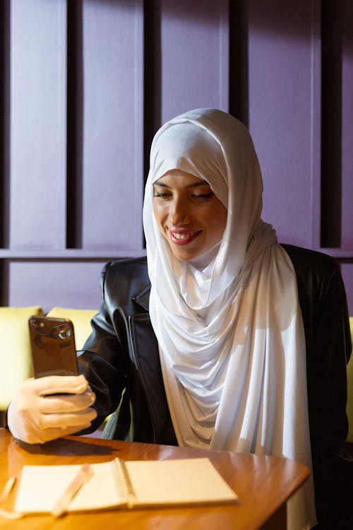 Free Woman in White Hijab Holding a Smartphone Stock Photo
