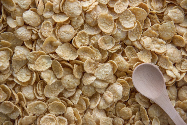 Bunch Of Brown Crunchy Cereals With Wooden Spoon