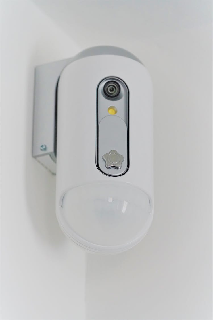 White Surveillance Camera Mounted On White Wall