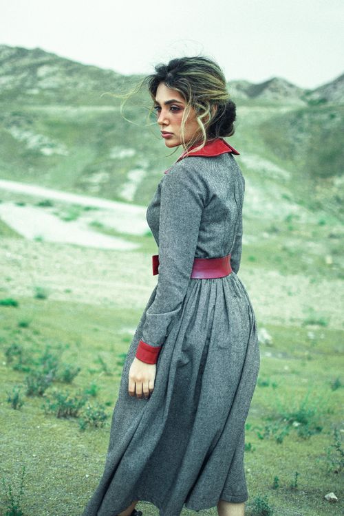 Free Young woman in vintage dress standing in a rural landscape captures timeless elegance. Stock Photo