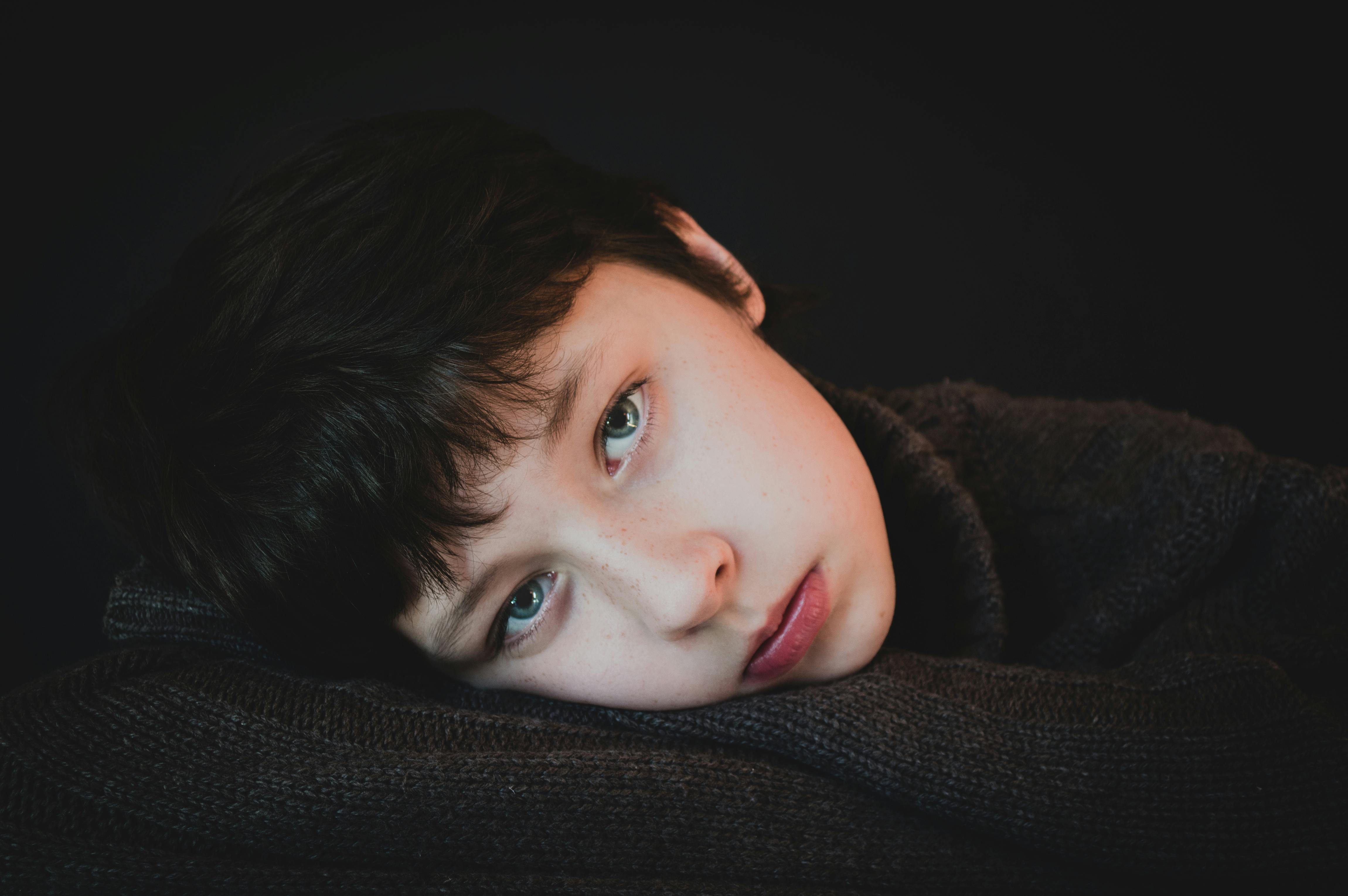 handsome boy with head on black textile