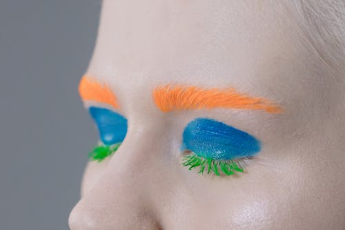 Free A Person With Blue Eyeshadow, Orange Eyebrows, and Green Eyelashes Stock Photo