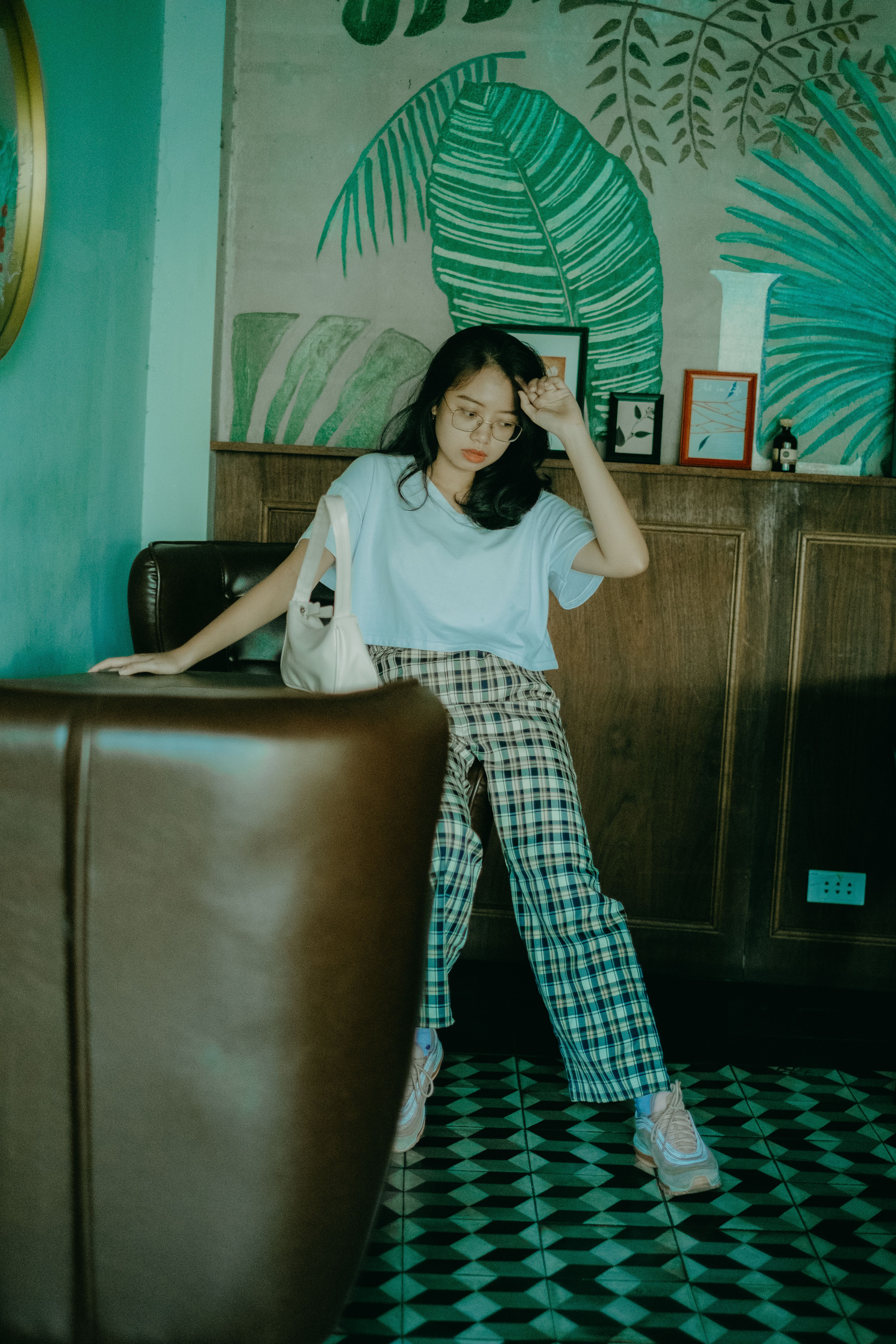 Teenager in casual attire sitting indoors with a modern aesthetic tone.