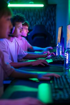 A group of young adults intensely focused on a gaming competition in a vibrant setting.
