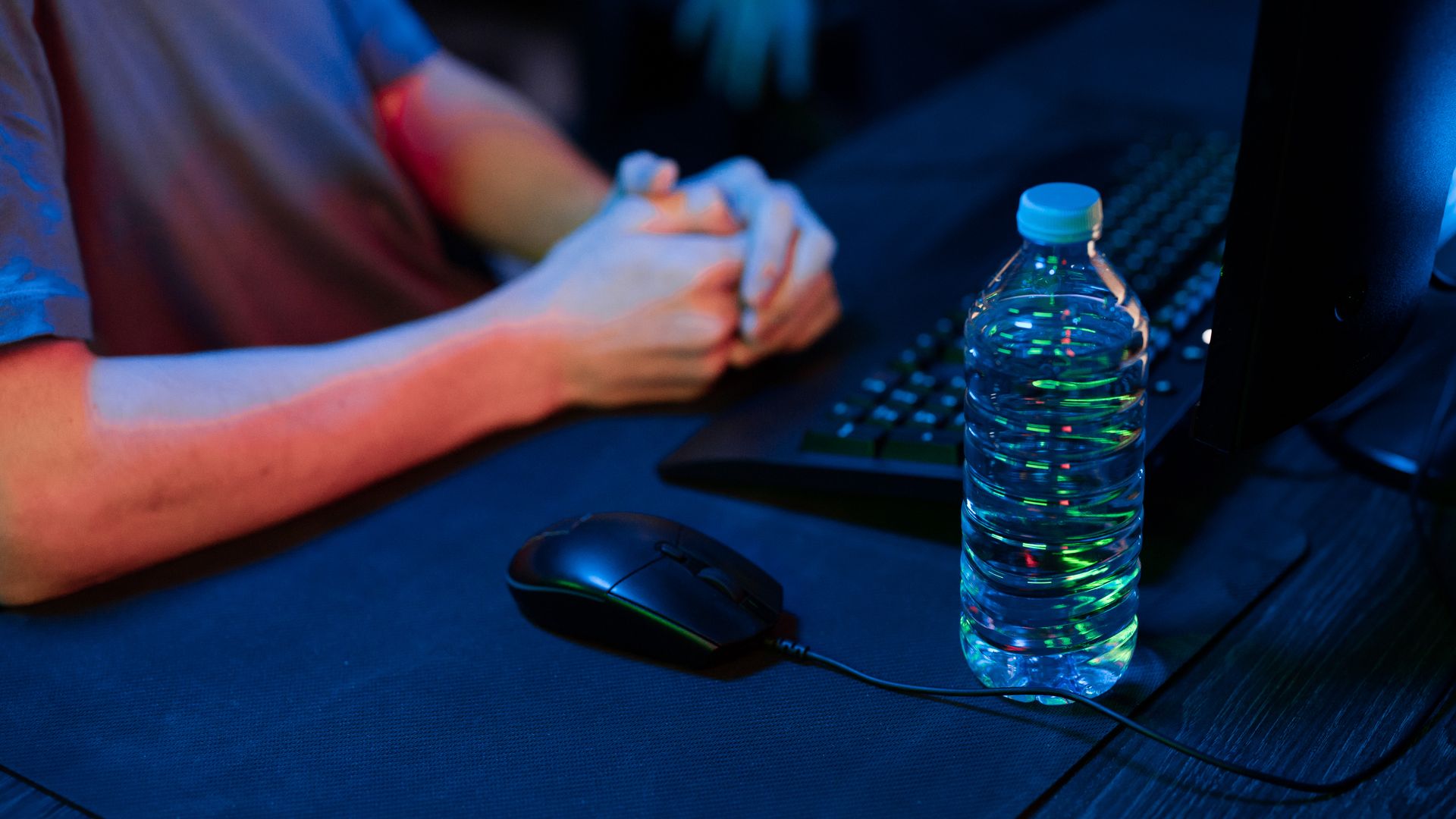 Modafinil for Esports Players: Enhancing Performance A close-up view of a gaming setup featuring a water bottle and computer mouse in a dimly lit environment — modafinil for esports players