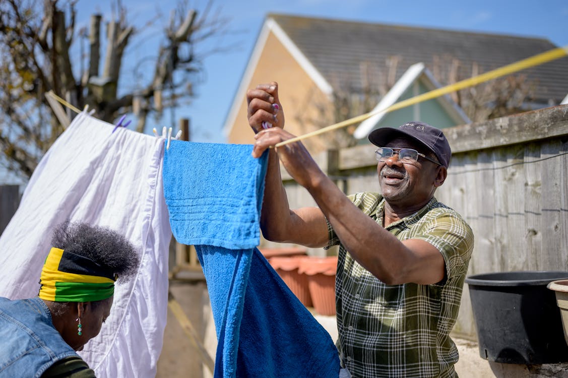 A Man Hanging a Towel on a Clothesline · Free Stock Photo