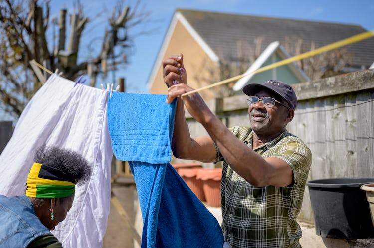 A Man Hanging A Towel On A Clothesline