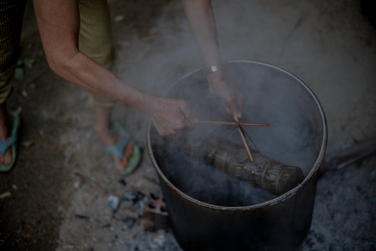 A Person Cooking On A Black Pot