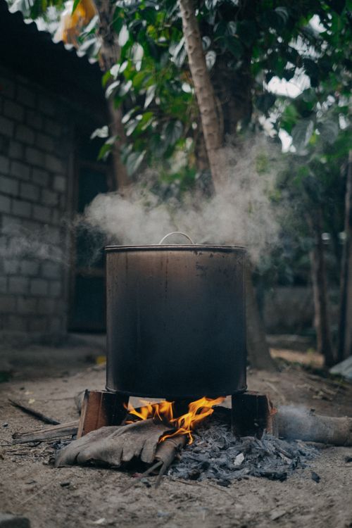Free Large pot steaming over firewood outdoors in Vietnam, showcasing rustic cooking tradition. Stock Photo