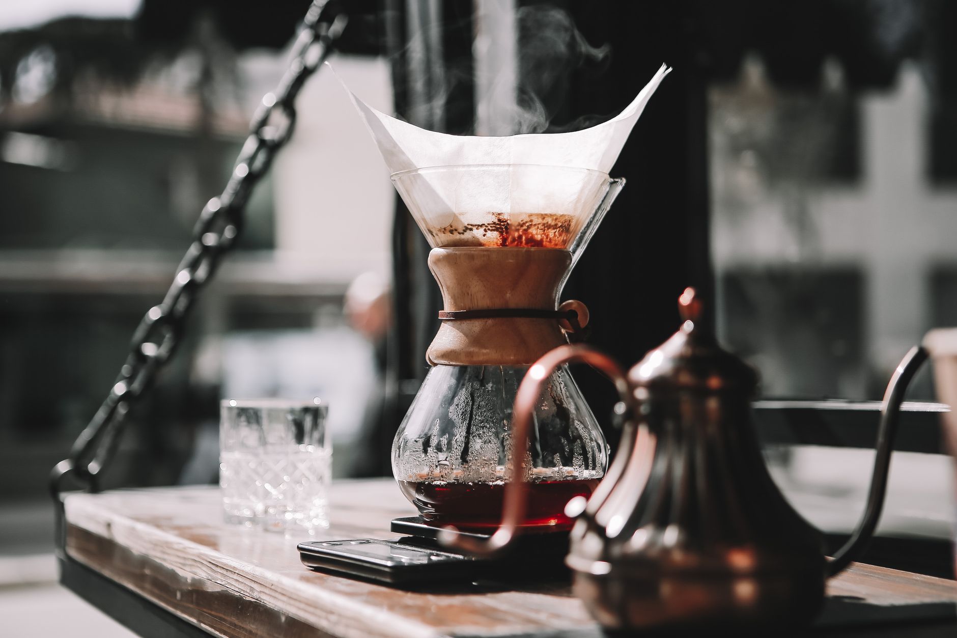 Artistic shot of steaming coffee pour over method in a cozy cafe setting, perfect for coffee enthusiasts.