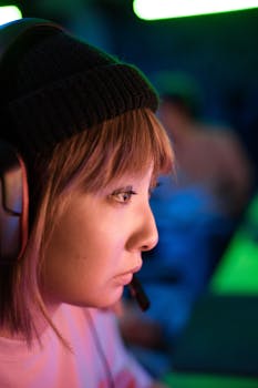 A woman with short blonde hair intensely focused while gaming wearing a headset.