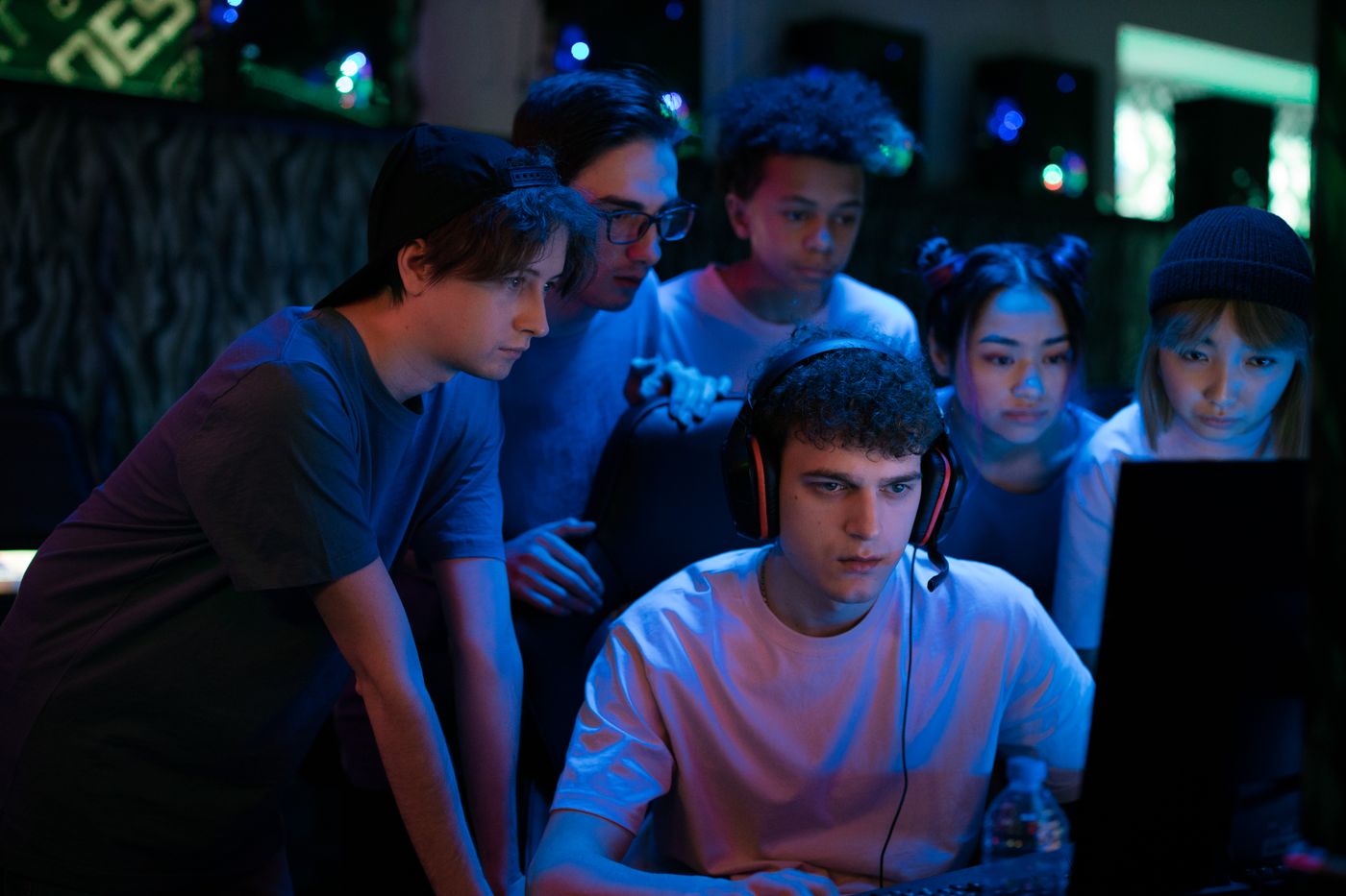 Young players crowding around a teammate's screen during a coached session