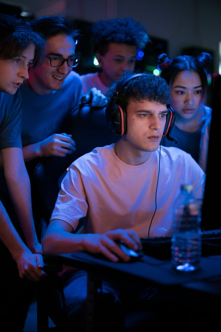 A Group Of People Watching A Man Playing Computer Game