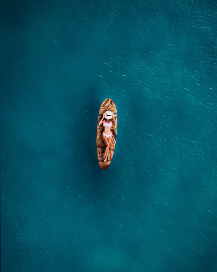 A Woman Lying Down On A Surfboard