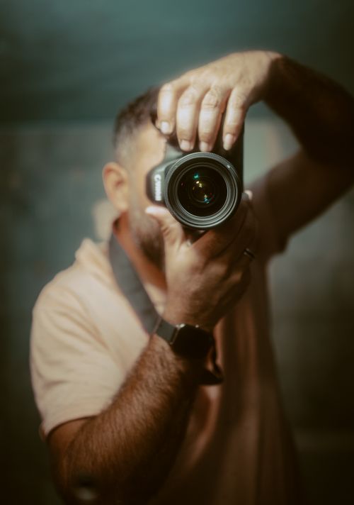 Free A photographer capturing an image through a camera lens. Ideal for photography themes. Stock Photo