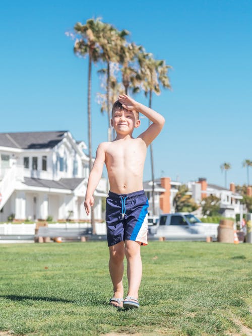 Shirtless Boy Walking on Grass