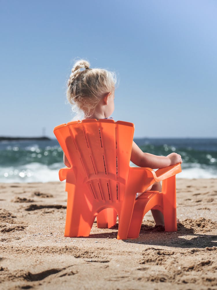 Girl Sitting On A Chair At A Beach 