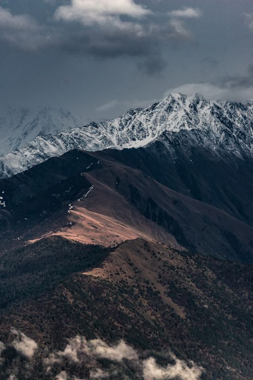 Free A striking view of snow-capped mountains under a gray sky, capturing the essence of winter. Stock Photo
