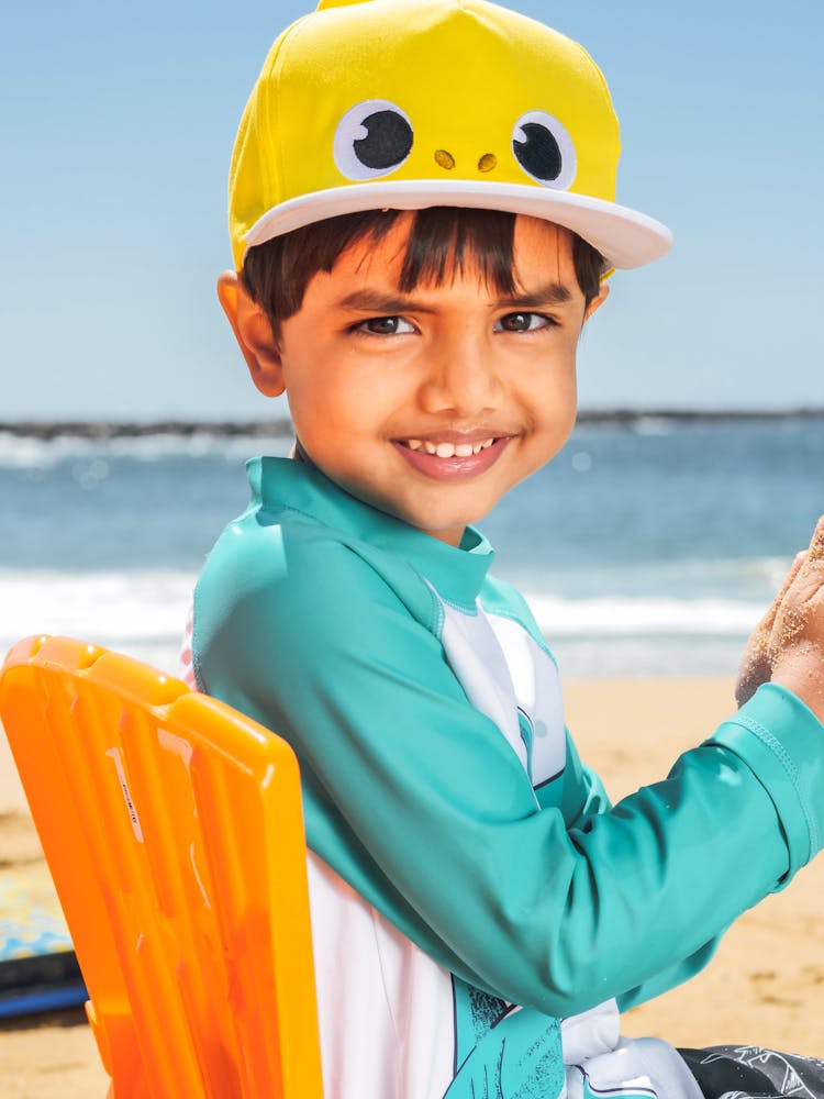 Boy In Blue Swimwear Wearing A Yellow Cap