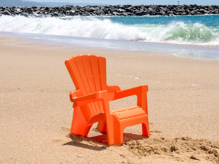 Orange Plastic Chair On Beach Shore