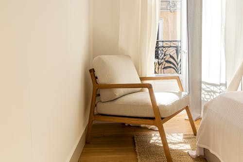 White and Brown Easy Chair Beside White Wall