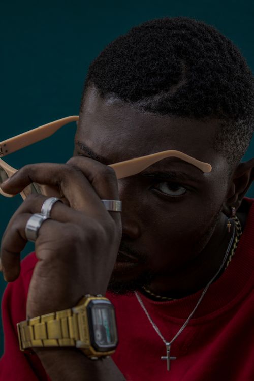 Free Serious black guy with metal accessories taking off sunglasses and looking at camera Stock Photo