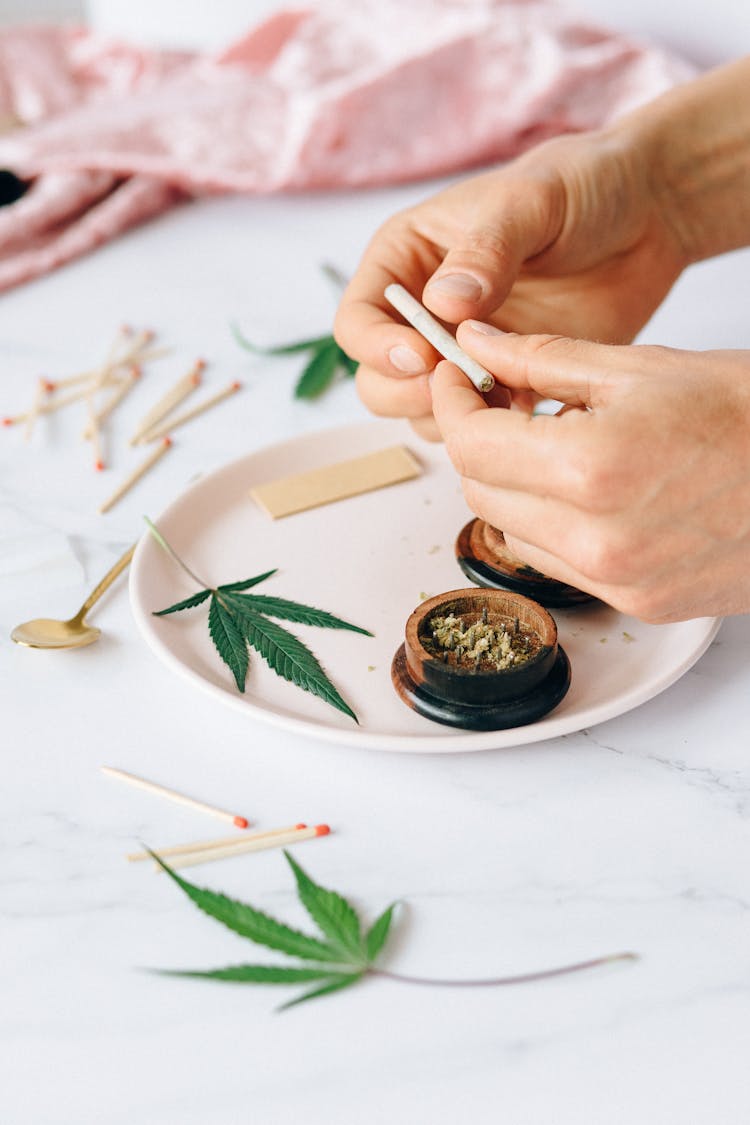 A Person Rolling Marijuana Cigarette