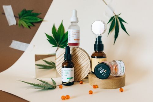 Free A collection of CBD oil products showcased with cannabis leaves on a neutral background. Stock Photo