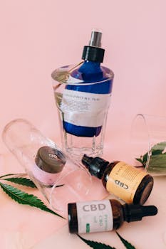 A selection of CBD-infused beauty products displayed on a light pink background.