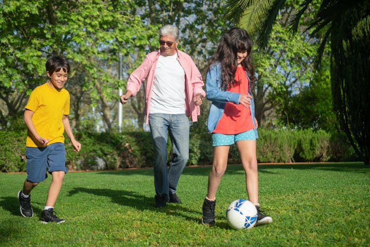 Man Playing Football With His Grandchildren 