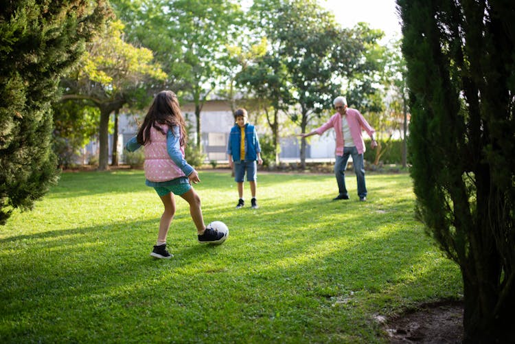 Grandfather Playing Football With His Grandchildren