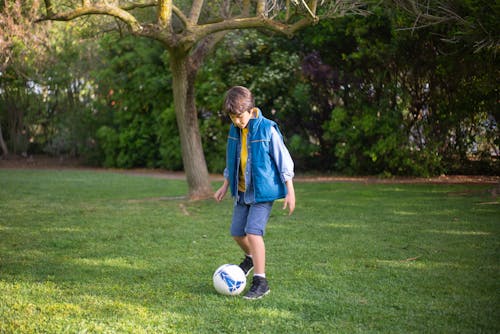 Boy Playing Football in a Park