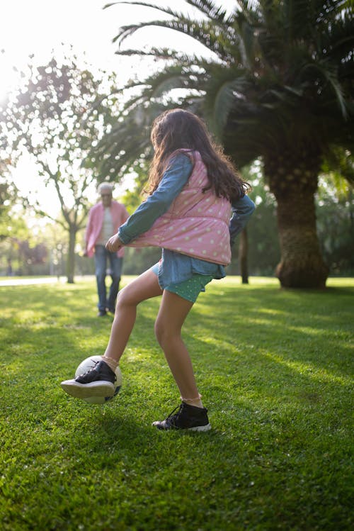 Free Girl Playing Soccer with her Grandfather Stock Photo