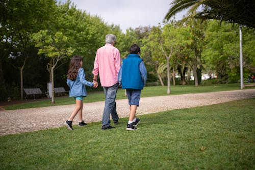 Free Elderly Man Walking at the Park with Grandchildren Stock Photo