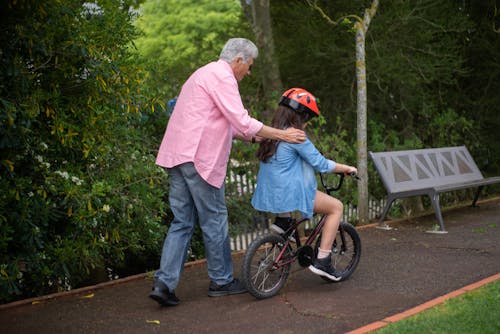 An Elderly Man Teaching His Grandchild to Ride a Bike